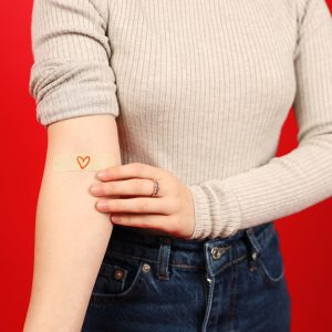 Close-up, a volunteer's hand with a band-aid after donating blood.